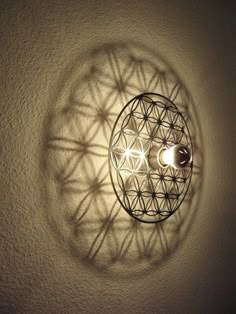 a light that is on the wall in front of a white wall with circles and stars