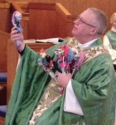 the priest is holding up his cell phone