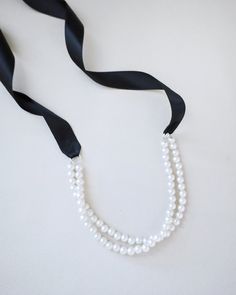 A delicate pearl necklace with a black satin ribbon closure is to add an effortless romantic and classic look to your formal or casual style. Perfect to complete your date night, wedding, bridesmaids, holiday party, and any special occasions. DETAILS:HANDMADEIMPORTED MATERIALS Elegant Black Pearl Necklace For Weddings, Elegant Adjustable Jewelry With Satin Bow, Elegant Adjustable Pearl Necklace For Evening, Elegant Black Pearl Necklace For Evening, Adjustable Ribbon Necklaces For Party, Elegant Adjustable Pearl Necklace For Formal Occasions, Black Ribbon Necklace For Party, Elegant Jewelry With Ribbon For Wedding, Elegant Black Pearl Necklace