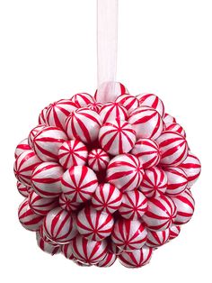 a red and white candy cane ball ornament hanging from a hook on a string