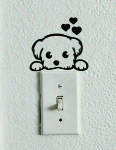 a white light switch with a black dog on it's face and hearts drawn on the wall