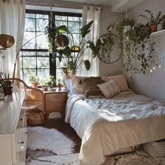 a bed room with a neatly made bed and lots of plants