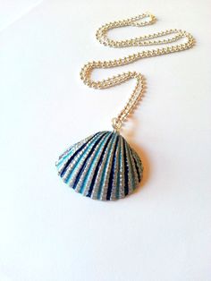 a blue and white shell necklace on a chain