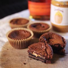 chocolate cupcakes with peanut butter filling on a cutting board next to honey bottles