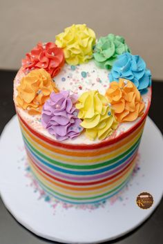 there is a cake decorated with multicolored icing flowers on the top and bottom