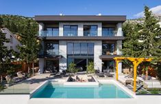 a house with a pool in front of it and lots of windows on the side