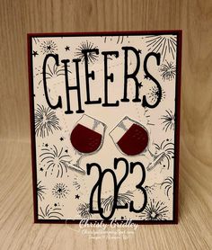 a card that says cheers on it with two glasses and fireworks in the sky behind it