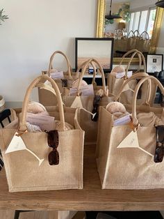 several bags with tags on them sitting on a table next to a mirror and other items