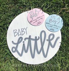 a wooden sign that says baby little on it's back in the green grass