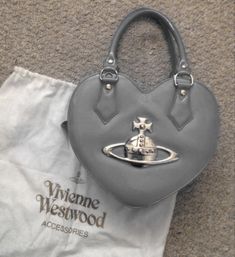 a gray purse sitting on top of a white bag