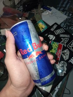 a hand holding a can of red bull energy drink