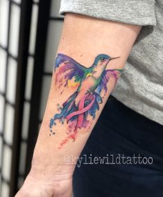 a colorful humming bird with a pink ribbon tattoo on the left forearm and right arm