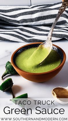 a spoon full of green sauce in a bowl