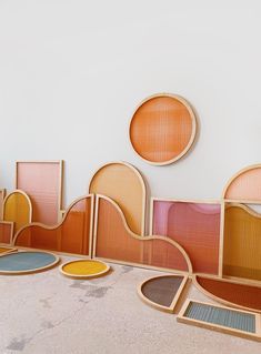 a room with several different colored chairs and mirrors on the wall, all made out of wood