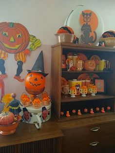 halloween decorations and pumpkins are displayed on a dresser