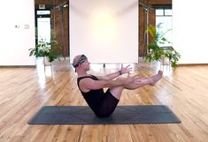 a man is doing yoga on a mat in an empty room with wood flooring