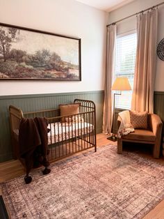 a baby's room with a crib, chair and rug