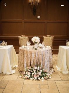 the table is set for two with white flowers and silver sequins on it