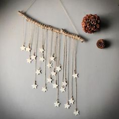 a mobile with stars hanging from it's side next to a pine cone on the wall