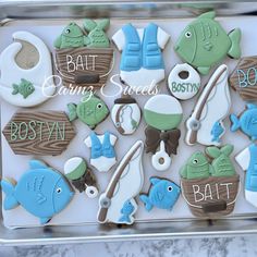 decorated cookies in the shape of boats and fish on a tray with words saying baking seeds