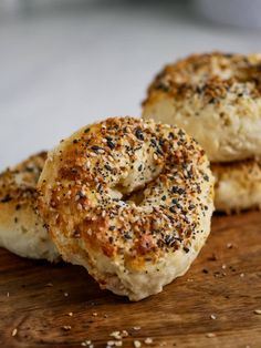 two bagels sitting on top of a wooden cutting board