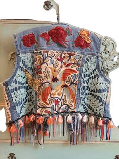 an old piece of clothing with flowers and tassels hanging from it's back