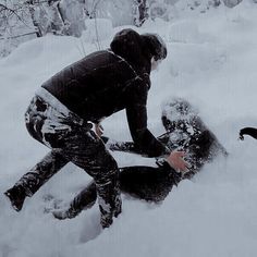 two people playing in the snow with each other