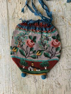 an embroidered purse hanging on the side of a wooden wall