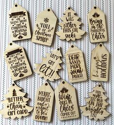 wooden tags with christmas sayings are arranged on a white and black tableclothed background