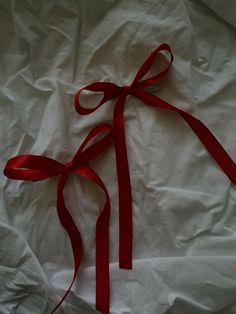 a red ribbon tied on top of a white sheet