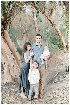 a family poses for a photo in the woods