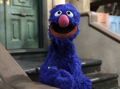 a blue stuffed animal sitting on top of a set of stairs