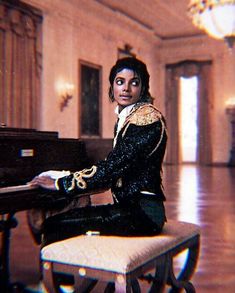 a man sitting on top of a bench next to a piano