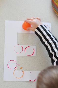 a young child is making a letter e craft