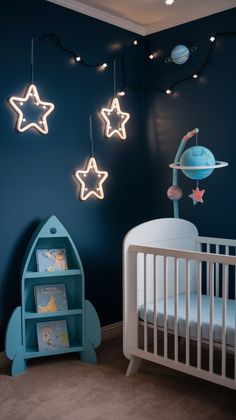 a baby's room with blue walls and stars hanging from the ceiling