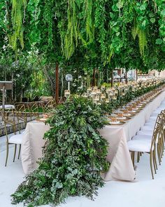 an outdoor dining area with tables and chairs covered in greenery