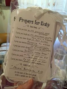 a person holding up a prayer card in a plastic bag with the words f prays for baby written on it