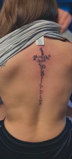 a woman with a cross tattoo on her back