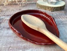 a wooden spoon sitting in a red bowl