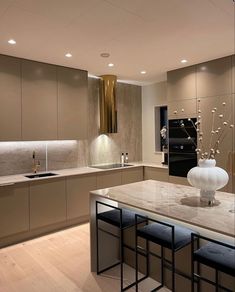 a modern kitchen with marble counter tops and stainless steel appliances