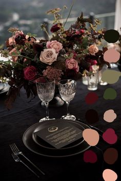 the table is set with wine glasses and flowers