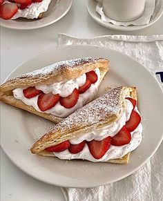 two pastries with strawberries are on a plate