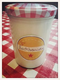 a jar of yogurt sitting on top of a red and white checkered table cloth