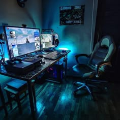 there is a computer desk with two monitors on it and a chair in front of it