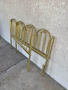 three gold metal racks on the side of a building next to a sidewalk and door