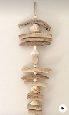 a wall hanging made out of driftwood and seashells on it's sides