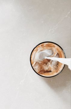 a person is pouring milk into a drink