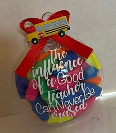 a glass ornament with a school bus on it and the words, the influence of a good teacher is whatever else