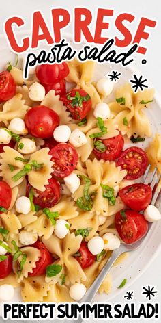 a white plate filled with pasta and tomatoes on top of a table next to a fork