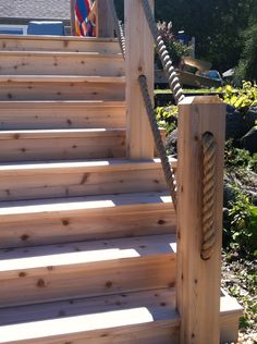 a wooden staircase with rope on the top and bottom